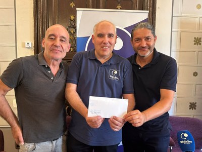 Josep Marsino, de SIMAC, lliura el xec solidari de 'Carretera i Manta' a Jordi Mas, com a representant d'Aliments per la Solidaritat de l'Alt Urgell