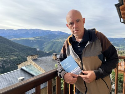 Albert Villaró a Estamariu, amb un exemplar del seu nou llibre i amb el Cadí de fons (Foto: ACN)