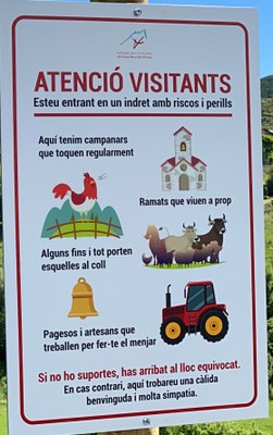 Detall del cartell d'avís als visitants en pobles agraris i ramaders