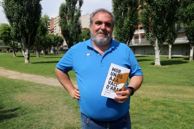 David Marín, a Balaguer, amb un exemplar de la seva novel·la inspirada en la mort de l'ós Cachou (Foto: ACN)
