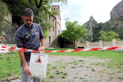 El director del Parc Natural de l'Alt Pirineu mostra el rètol que indica els motius del tancament de l'accés al santuari d'Arboló (Foto: ACN)