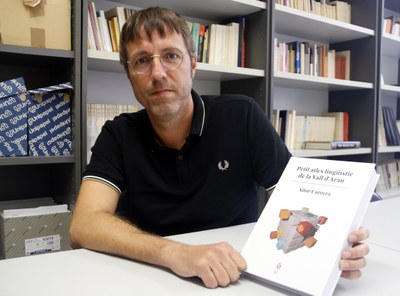 Aitor Carrera mostra un exemplar del 'Petit atles lingüístic de la Vall d'Aran' (Foto: ACN)