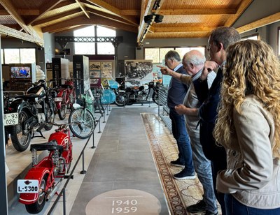 Estanislau Soler explica a José Crespín i a Cristina Barbens el contingut del Museu de la Moto de Bassella