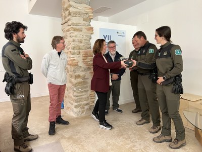 Sílvia Romero lliura als agents rurals aparells de videovigilància per a espais del Geoparc Orígens, com el Mirador del Cretaci (Foto: ACN)