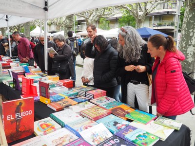 Vianants trien llibres en una de les parades de Sant Jordi instal·lades al passeig Joan Brudieu de la Seu
