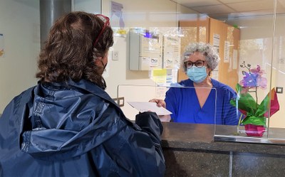 Lliurament d'un document de baixa mèdica a un familiar d'un pacient, a la recepció del Sant Hospital de la Seu (Foto: Dep. Salut)