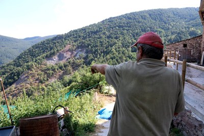 Un veí de Mencui assenyala una esllavissada a tocar del poble (Foto: ACN)