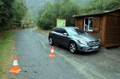 Caseta i vigilant que controla l'accés als aparcaments que donen accés a la Pica d'Estats i un vehicle sortint de la zona (Foto d'arxiu/ACN)