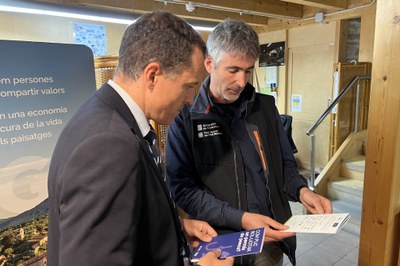El conseller d'Agricultura, Ramaderia, Pesca i Alimentació, Òscar Ordeig, amb un fulletó que explica com obtenir un permís de pesca al costat del director del Parc Natural de l'Alt Pirineu, Marc Garriga (Foto: ACN/Albert L. Cobo)