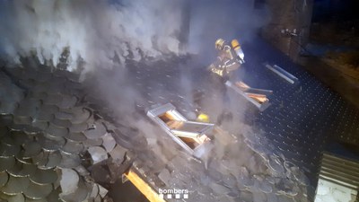 Els Bombers treballant en l'extinció del foc a la coberta d'una casa d'Araós (Foto: Bombers de la Generalitat)