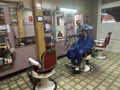 Joan Ribera atén un client a la seva barberia del carrer Major, que conserva elements de fa gairebé un segle (Foto: RàdioSeu)