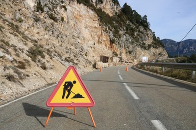 Carretera que puja de Coll de Jou fins al Port del Comte amb un senyal d'obres en primer terme (Foto: ACN)