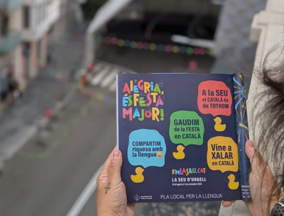 Un exemplar del llibret de la Festa Major, amb l'escenari de la plaça de Catalunya al fons (Foto: CUP La Seu)
