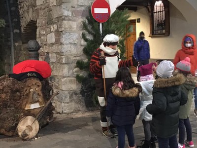 Uns infants saluden un minairó a la plaça de Sant Roc, al costat del tió que homenatja el 'Truqui'