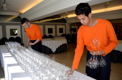 Dos alumnes fent pràctiques de com portar les copes amb les mans a l'Hotel Pessets de Sort (Foto d'arxiu/ACN)