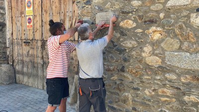 Instal·lació d'una placa a Ca l'Estorc de Llívia, amb el nom tradicional de la casa (Foto: ACN)