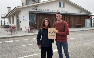 Dos portaveus de la nova plataforma Pirineu Viu, Júlia Leigh i Arnau Corberó, amb el cartell de l'organització a l'exterior de la terminal de l'aeroport d'Andorra-La Seu d'Urgell (Foto: ACN/Albert L. Cobo)