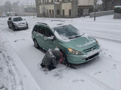 Un conductor posa les cadenes al seu cotxe