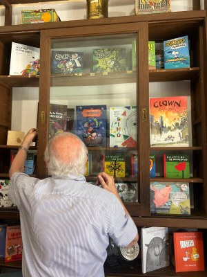 Ramon Besora repassa els llibres exposats a les poselles de Casa Rotxé, que ha reobert com a llibreria (Foto: Edicions Salòria)