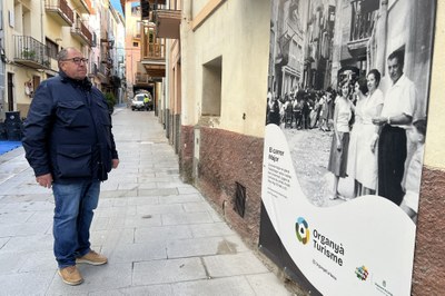 Celestí Vilà observa, al carrer Major d'Organyà, una de les fotografies antigues de grans dimensions instal·lades a la vila (Foto: ACN)