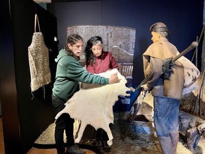 El mestre artesà Edu Marín mostra una pell d'ovella, al costat de diverses peces de pastor fetes amb aquest material (Foto: ACN)