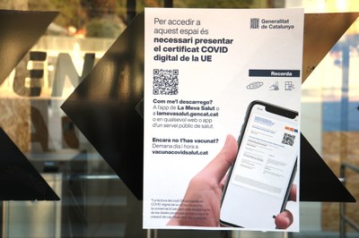Cartell en un establiment sobre l'obligatorietat del passaport COVID