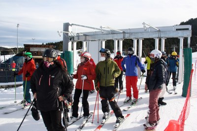 Els primers esquiadors, equipats amb mascareta i forfet mans lliures, accedeixen al telecadira Jumbo Tosa de Masella (Foto: ACN)