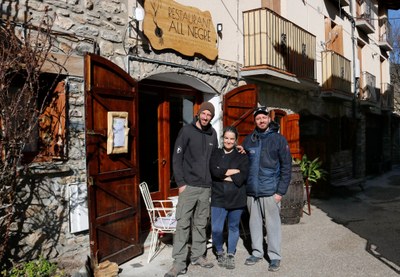 Els impulsors d'un restaurant vegetarià cooperatiu a Montardit de Baix, a l'entrada del seu local (Foto: ACN)