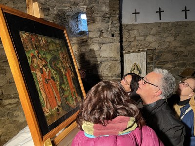 Persones mirant la taula del retaule gòtic d’Escalarre que representa l'escena de Sant Martí (Foto: ACN/Marta Lluvich) 